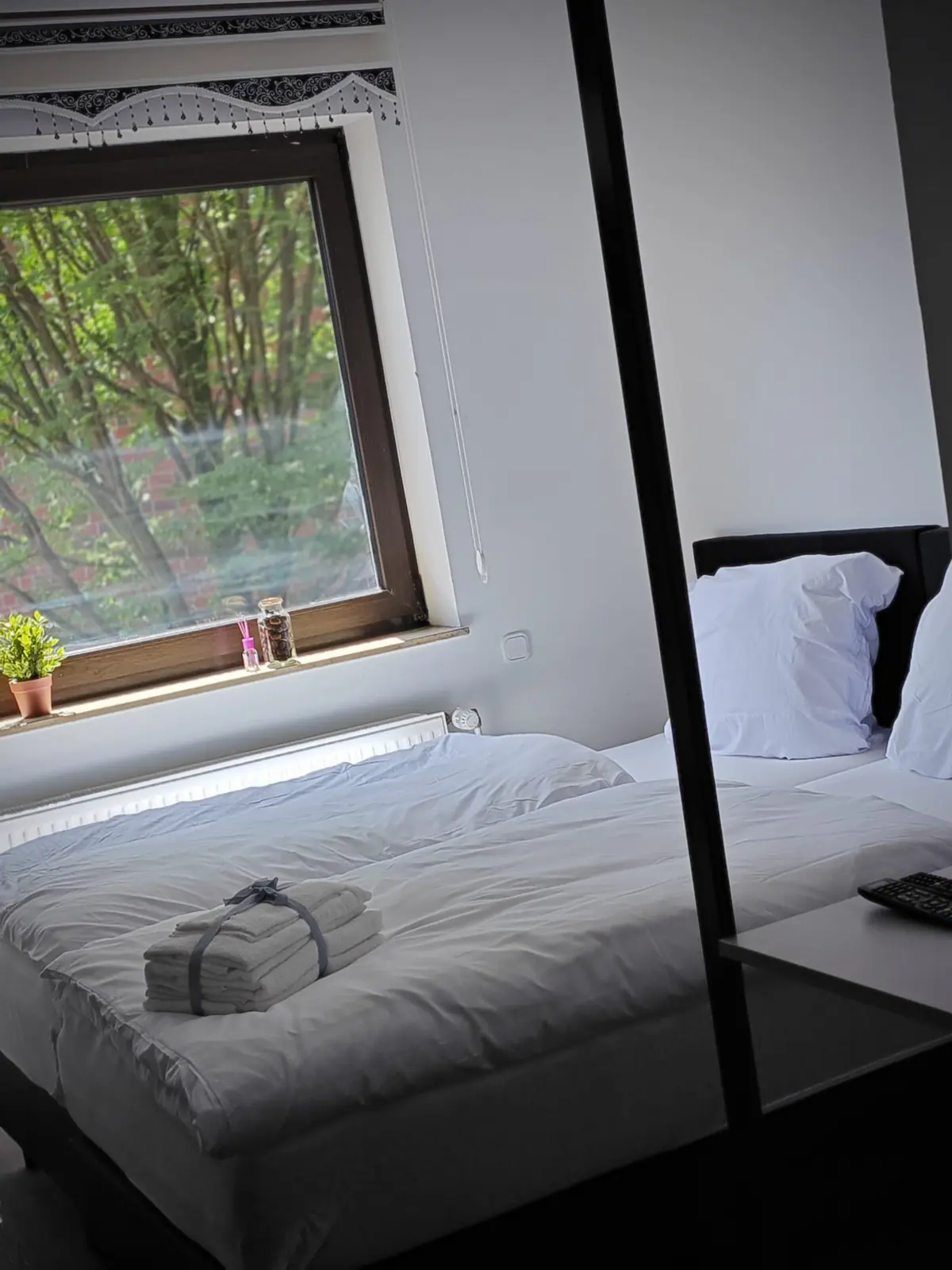 Doppelbett mit Spiegelung im raumhohen Spiegel neben dem Schreibtisch